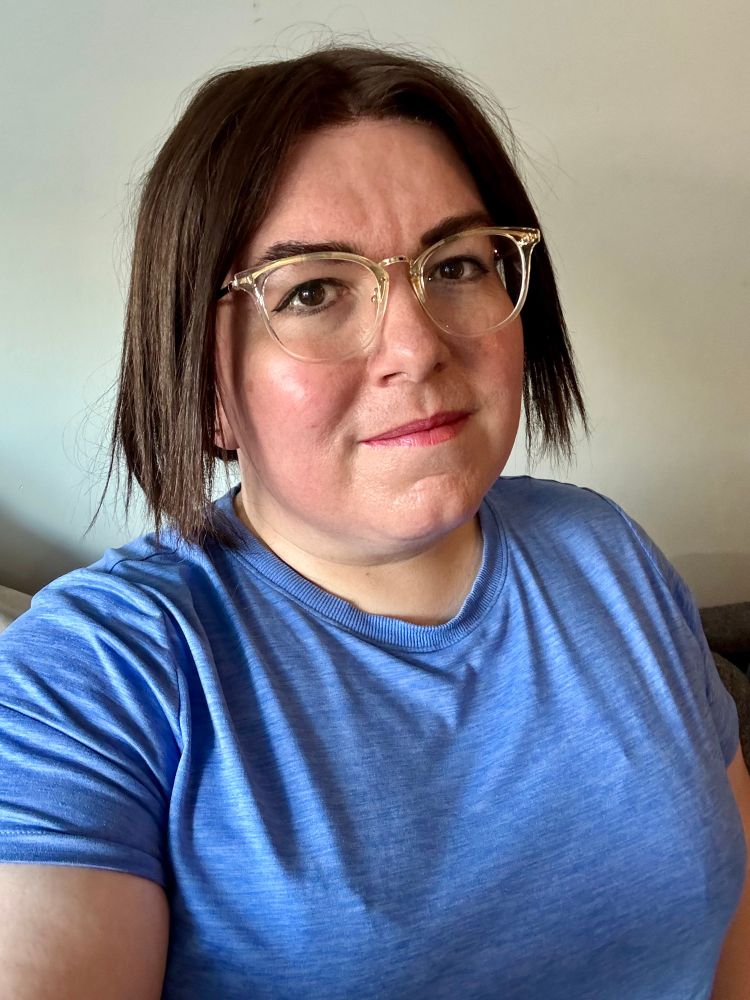 it's Nora! she has eyeliner on (and light makeup), she's wearing a blue athleisure top and her dark brown hair is half up