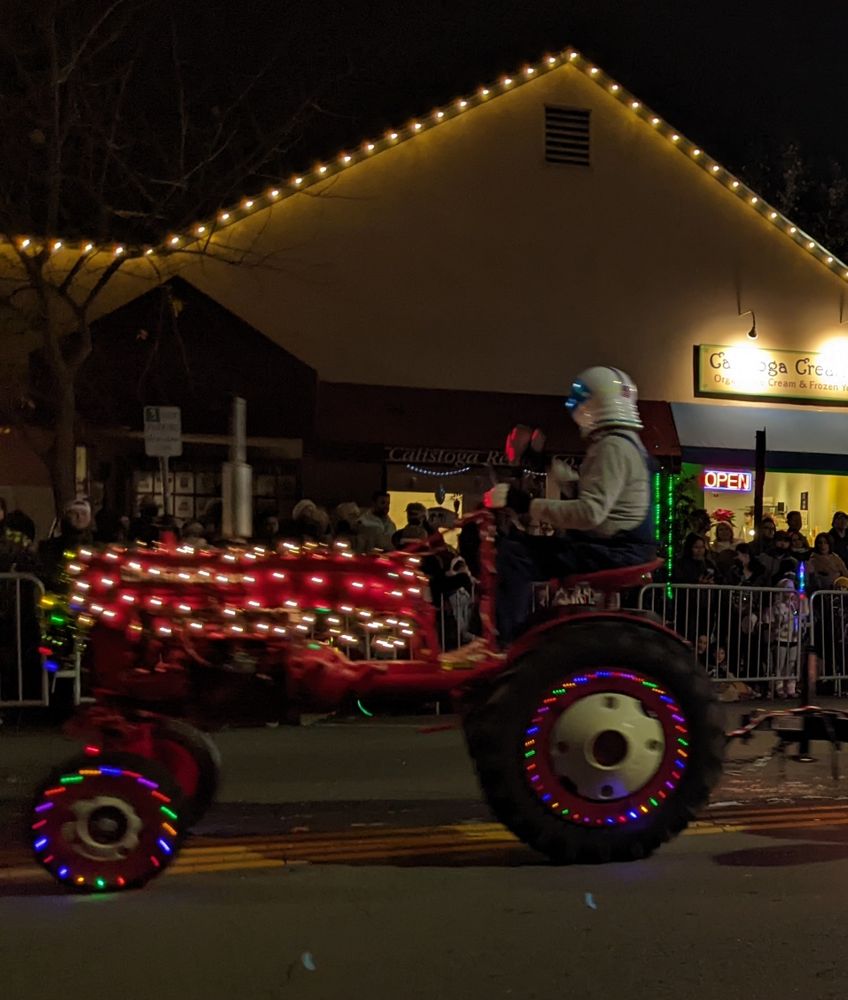 Tractor with holiday lights and...an astronaut(?) driving. 