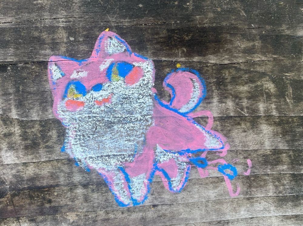 pastel drawing on a picnic table of Prince K smiling and lifting his leg and pissing