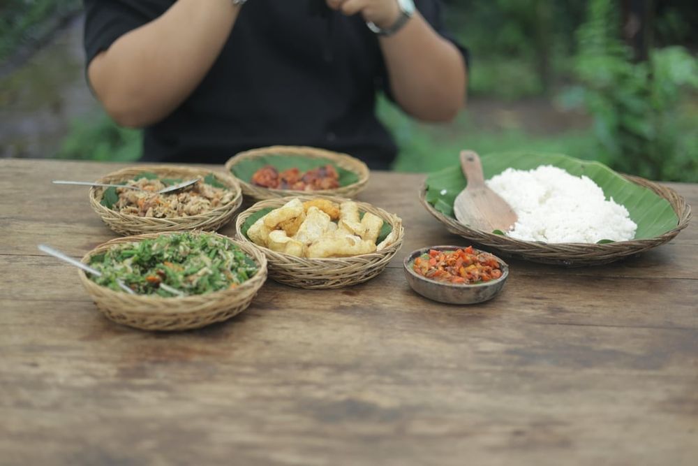 Beberapa minggu yang lalu akhirnya gw jadi mencoba tempat makan urutan babi asap yang sempat viral beberapa bulan / tahun yang lalu.

Nama outlet ini adalah Standar Lokal, cukup unik. Lokasinya di penebel, tabanan, bali. Cukup jauh dari kota, sekitar 2 jam.

Menunya fix, tidak ada menu yang lain. Lu dapet 1 porsi urutan babi asap, 1 porsi ayam sisit asap, 1 porsi sayur lawar paku, 1 porsi krupuk babi, 1 porsi sambal dan 1 porsi nasi putih.

Porsinya akan menyesuaikan berapa orang yang reservasi.

Urutan babi asap: Cukup enak, tapi kurang nendang smoky flavournya. Rasanya menurut gw malah lebih condong ke lap chiong, kaya lap chiong asap, tapi ga manis. Banyak rempah, daging dan lemaknya juga cukup seimbang lah. 4 / 5

Ayam sisit asap: Best, star of this outlet. Rasa smokynya jauh lebih nendang dari urutan babi asapnya. Trus balance rasa manis dan pedasnya sangat asik, sexy sih hahaha. 5 / 5

Lawar paku. Lawar adalah sayur tradisional bali, biasanya campuran sayur2an yang dicincang diisi rempah, bumbu bali, kadang daging, kadang bahkan isi darah mentah. Yang ini tenang aja ga isi darah, cuma sayur paku, paurtan kelapa, kacang2an, cabe dan bawang. Oke banget menurut gw, fresh dan jarang gw temuin lawar paku. 5 / 5

Krupuk babi. Need i say more? 5 / 5

Nasi putih. Kadang suka dianggap sepele. Tapi nasi adalah dasar yang harus dipastikan dimasak secara pas dan hangat. 5 / 5

Per orang di charge 50rb, total kita ber3 150rb sudah termasuk air minum. Nice!

Cons:

Jauh, 2 jam dari denpasar, kuta, seminyak dan juga canggu. Bisa 3 jam kalau dari nusa dua

Wajib reservasi, no reservasi no eat

Whatsapp reservasinya kadang balasnya agak lambat

Ga bisa nambah di tempat, you get what you reserve. So kalau mau take away atau mau nambah harus info di awal waktu reservasi. Karena mereka buat semuanya sangat limited.

Consnya lebih ke situasi sih, bukan ke makananannya, jadi overal s

___
📸 Image credit: u/baliadv1122
🔗 Source: https://reddit.com/r/kulineria/comments/1pacedf/standar_lokal_urutan_babi_asap_tabanan_bali/

#kulineria #food #indonesia