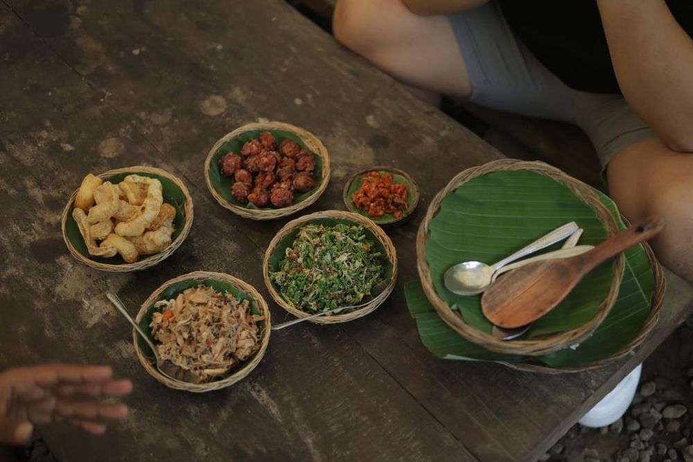 Beberapa minggu yang lalu akhirnya gw jadi mencoba tempat makan urutan babi asap yang sempat viral beberapa bulan / tahun yang lalu.

Nama outlet ini adalah Standar Lokal, cukup unik. Lokasinya di penebel, tabanan, bali. Cukup jauh dari kota, sekitar 2 jam.

Menunya fix, tidak ada menu yang lain. Lu dapet 1 porsi urutan babi asap, 1 porsi ayam sisit asap, 1 porsi sayur lawar paku, 1 porsi krupuk babi, 1 porsi sambal dan 1 porsi nasi putih.

Porsinya akan menyesuaikan berapa orang yang reservasi.

Urutan babi asap: Cukup enak, tapi kurang nendang smoky flavournya. Rasanya menurut gw malah lebih condong ke lap chiong, kaya lap chiong asap, tapi ga manis. Banyak rempah, daging dan lemaknya juga cukup seimbang lah. 4 / 5

Ayam sisit asap: Best, star of this outlet. Rasa smokynya jauh lebih nendang dari urutan babi asapnya. Trus balance rasa manis dan pedasnya sangat asik, sexy sih hahaha. 5 / 5

Lawar paku. Lawar adalah sayur tradisional bali, biasanya campuran sayur2an yang dicincang diisi rempah, bumbu bali, kadang daging, kadang bahkan isi darah mentah. Yang ini tenang aja ga isi darah, cuma sayur paku, paurtan kelapa, kacang2an, cabe dan bawang. Oke banget menurut gw, fresh dan jarang gw temuin lawar paku. 5 / 5

Krupuk babi. Need i say more? 5 / 5

Nasi putih. Kadang suka dianggap sepele. Tapi nasi adalah dasar yang harus dipastikan dimasak secara pas dan hangat. 5 / 5

Per orang di charge 50rb, total kita ber3 150rb sudah termasuk air minum. Nice!

Cons:

Jauh, 2 jam dari denpasar, kuta, seminyak dan juga canggu. Bisa 3 jam kalau dari nusa dua

Wajib reservasi, no reservasi no eat

Whatsapp reservasinya kadang balasnya agak lambat

Ga bisa nambah di tempat, you get what you reserve. So kalau mau take away atau mau nambah harus info di awal waktu reservasi. Karena mereka buat semuanya sangat limited.

Consnya lebih ke situasi sih, bukan ke makananannya, jadi overal s

___
📸 Image credit: u/baliadv1122
🔗 Source: https://reddit.com/r/kulineria/comments/1pacedf/standar_lokal_urutan_babi_asap_tabanan_bali/

#kulineria #food #indonesia