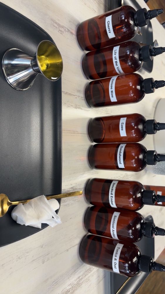 Scent bottles for candle making labeled from top to bottom: Cherry, Lily of the Valley, Vintage Wine, Sage, Sandalwood, Smoked Ember, Sensual Amber, Tonka & Oud