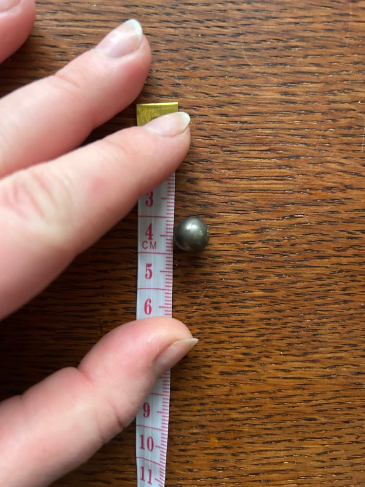 A ball bearing next to a tape measure. It measures about 9mm
