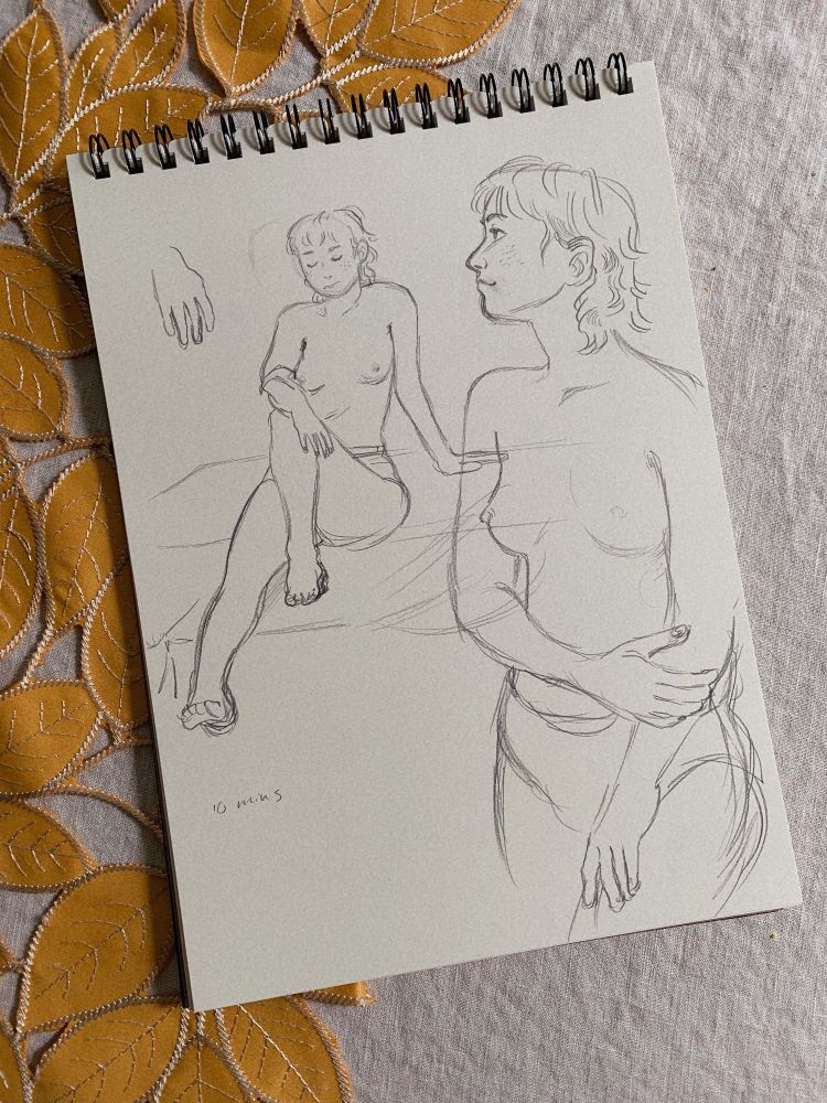 A photo of a sketch pad with sketches of someone in two different poses. These were 10 minute poses.