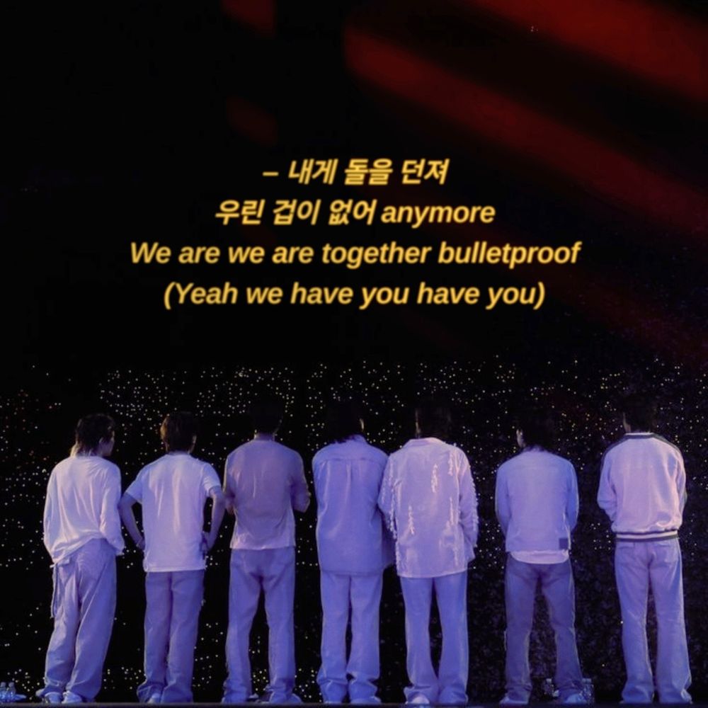 All 7 members of BTS facing the crowd.
At the top there are the lyrics "우린 겁이 없어 anymore
We are we are together bulletproof
(Yeah we have you have you)"