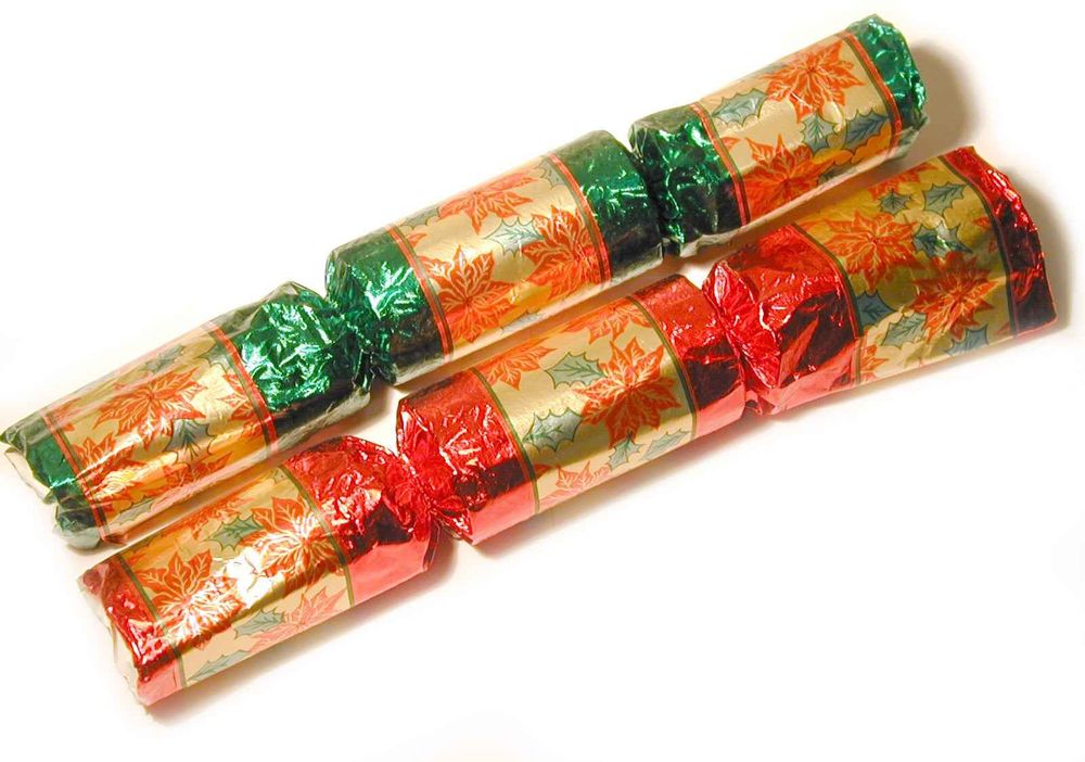 A photo of two Christmas crackers lying parallel next to one another.