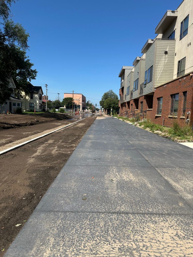 Bike path under construction showing a wide paved path next to dirt road.