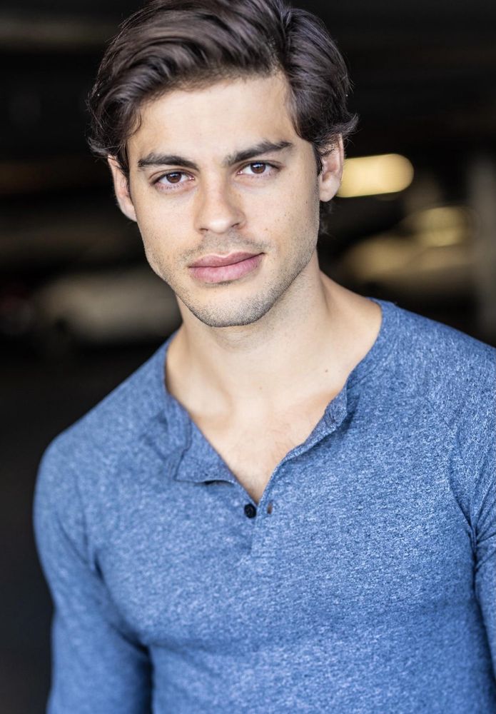 Chris petrovski IMDb headshot looking ripped in a Henley with dark hair and stubble. 