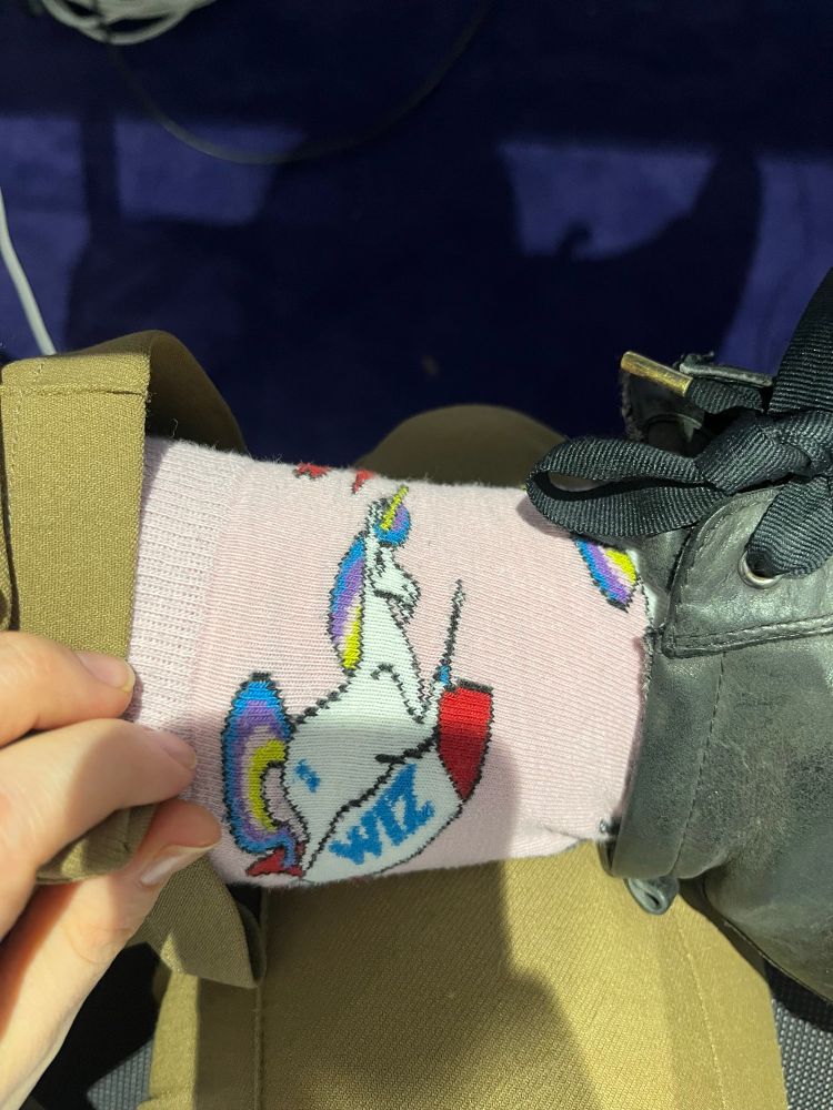 Pink socks with unicorn riding a rocket. 