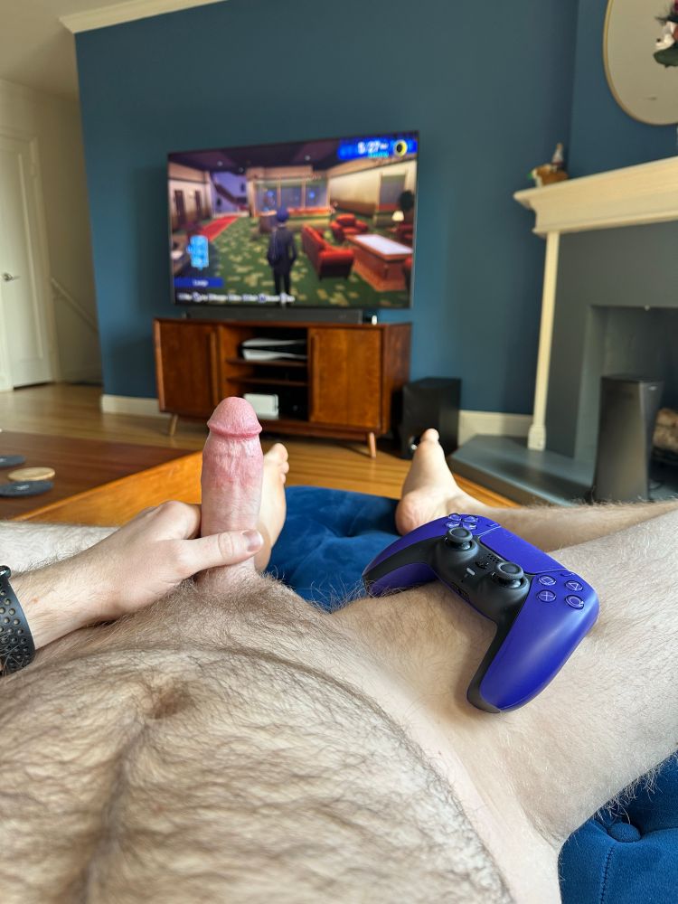 A picture of my hard cock with a PS5 controller next to it and Persona 3 Reload on the TV in the background 