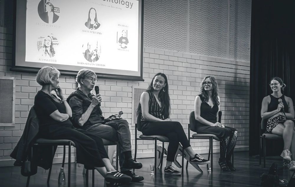 A black and white photo featuring (from left to right): Doris, Pat, Adele, myself, and Sally. Pat is speaking while we all look on, contemplative or smiling.