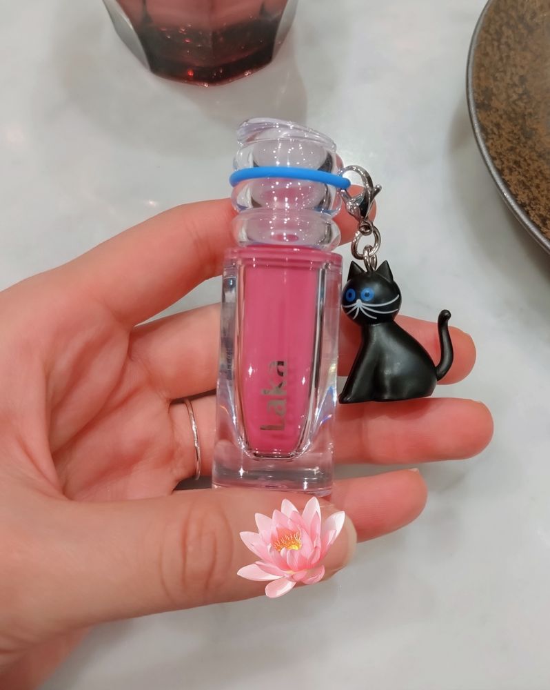 Lakaのリップティント、614番。青みの強いピンク色。透明のリップケースに青い目の黒猫のチャームを付けた