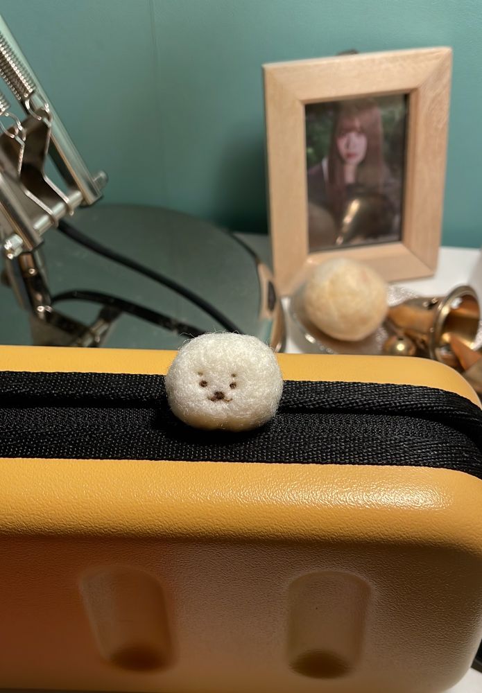 羊毛フェルトで作ったあざらしの写真。百円玉とほぼ同じ大きさ。