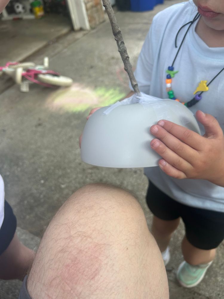 A bowl tapped to the end of a stick 