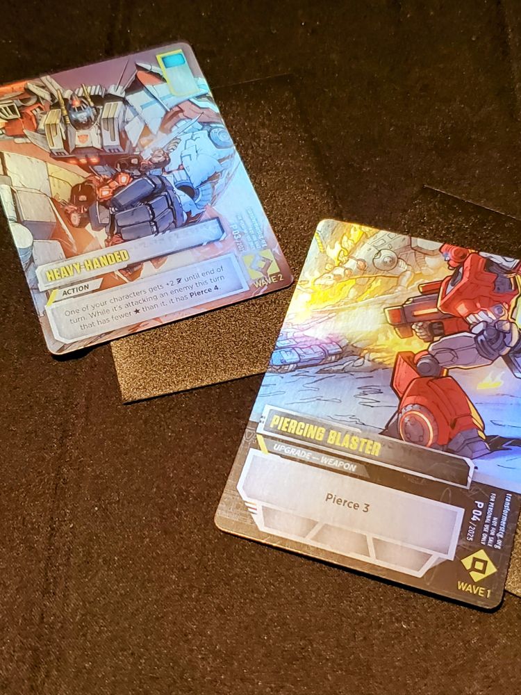 Two foil Electrum variant Transformers TCG battle cards selected randomly from the Blind Draw shoe.