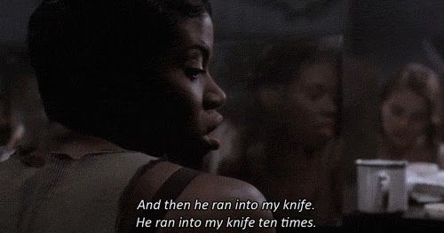 A screenshot from the movie musical Chicago. A Black woman in 1920's prison clothes looks to her right and says, "And then he ran into my knife. He ran into my knife ten times."