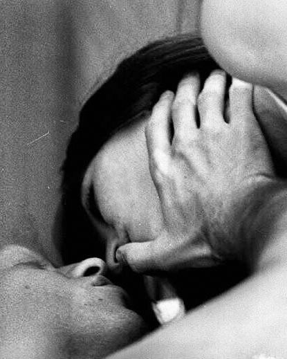 black and white photo of a couple: the man is caressing the cheek of the woman with his thumb 