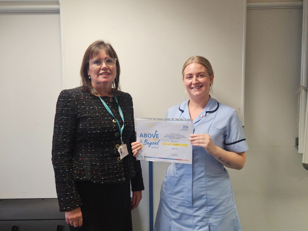 Woman presenting another woman in nursing uniform with certificate