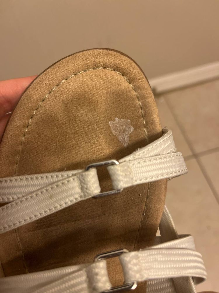 The bottom of a sandal with a faint bit of worn out sticker on it. The design is not visible.