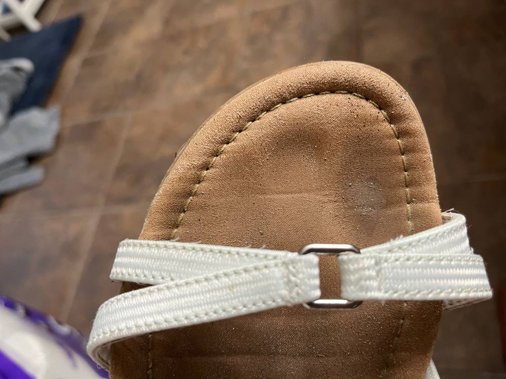 The bottom of a sandal with sweaty toe imprints.