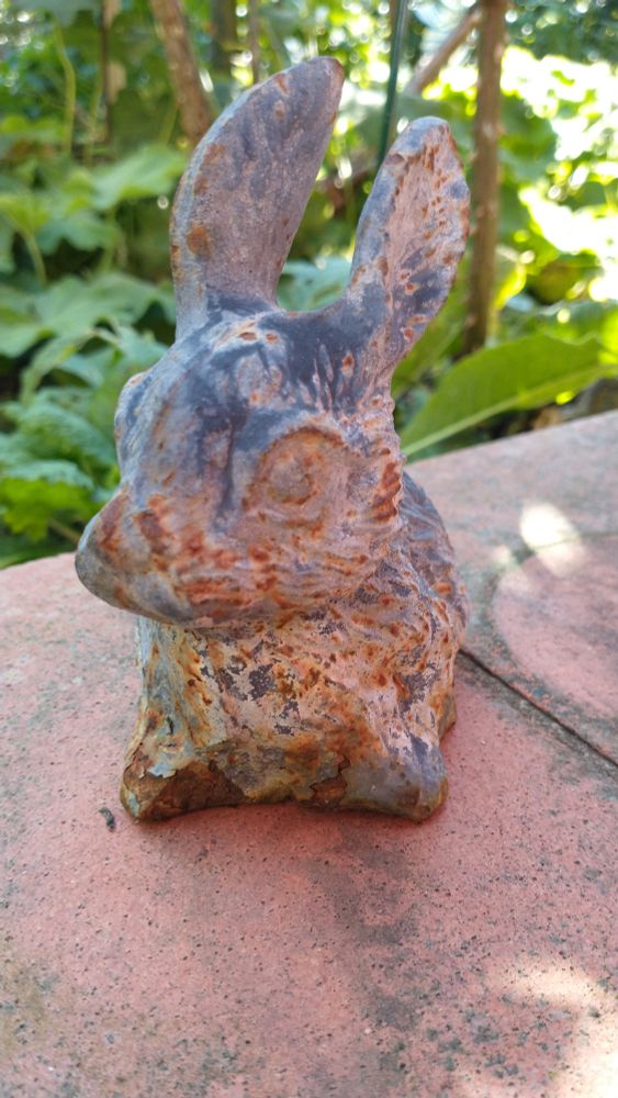 Kleiner Hase aus Metall mit rostigen Stellen.