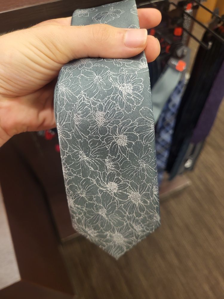 A tie with a stitched white floral design