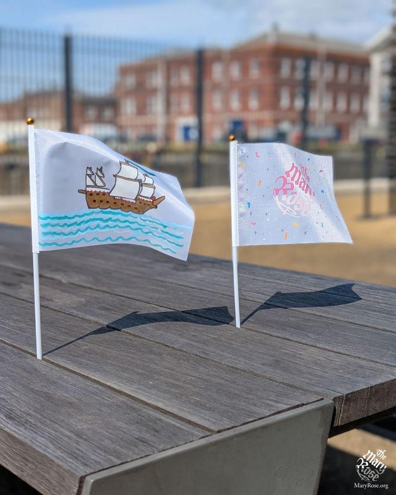A pair of flags depicting the Mary Rose and the logo.