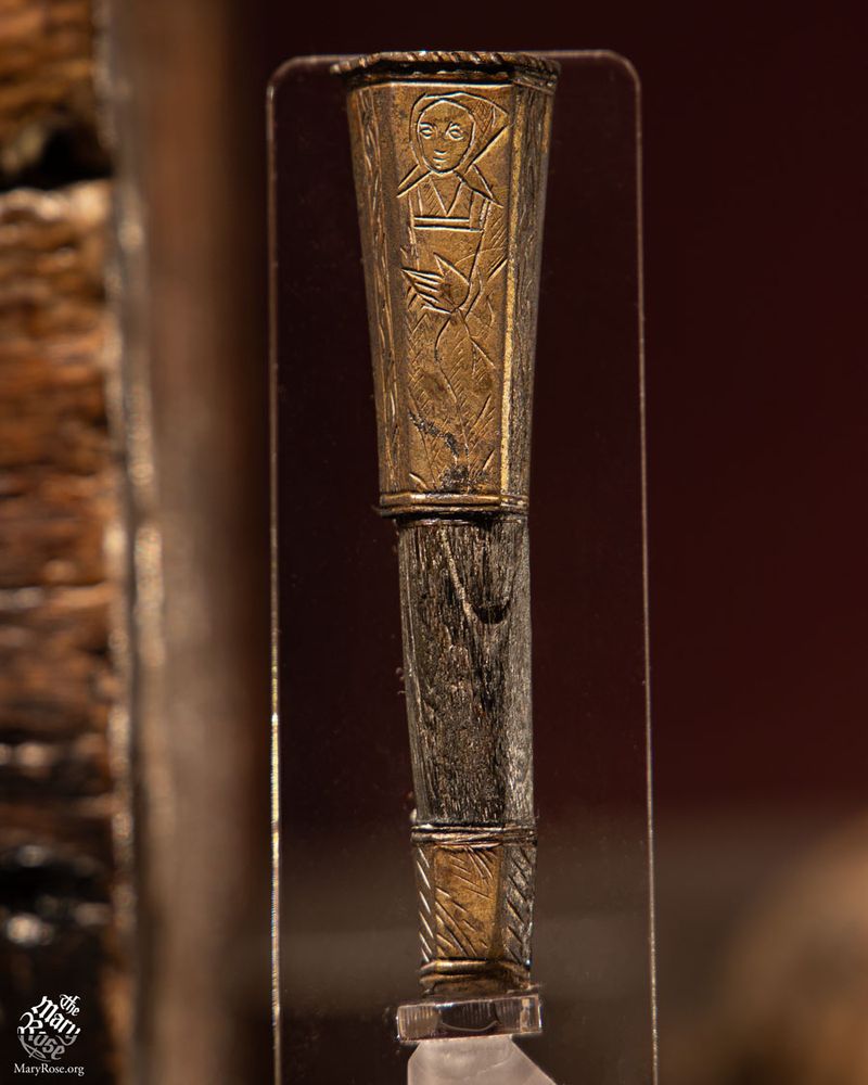 Knife handle featuring a female figure on a brass cap, mounted on a wooden shaft