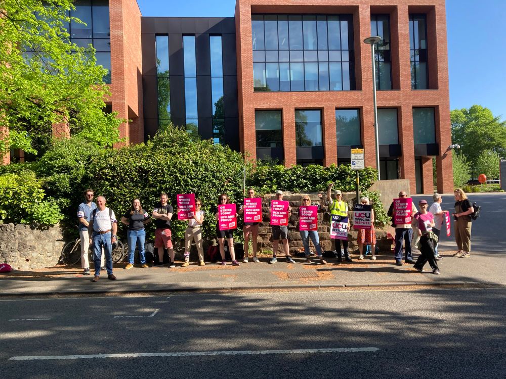 People standing in front of a building with strike signs