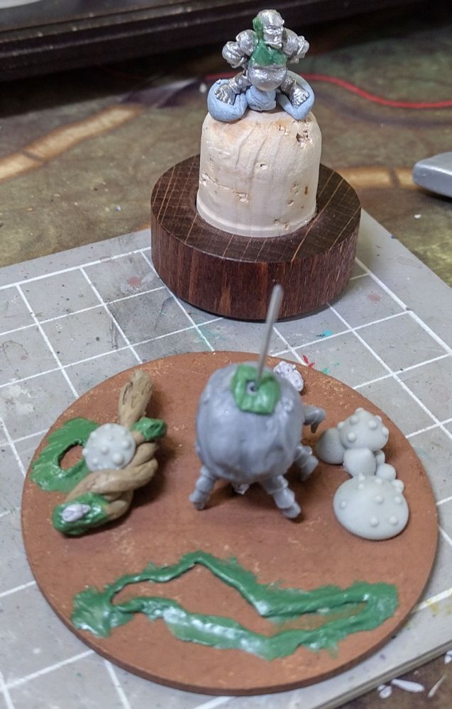 Goblin on cork with sculpted extra bits behind a big scenic base with various fungal and puddle decorations shaping up. 