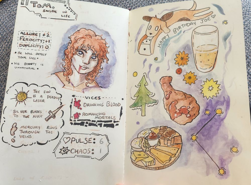 An open sketchbook. The art and drawing is pen and watercolours. On the left is s character sheet for a vampire named Tom. His portrait shows him pale, with blood on his lip, blue eyes and ginger hair. His vices are drinking blood and romancing mortals. On the right is a flow of doodles - a dog carries a dice, and it says happy birthday Joe underneath. There is a half drunk pint of beer, a Christmas tree, a piece of fried chicken, various stars, and a cheeseboard all illustrated and dotted around the page. Both pages have bluey purple watercolor backgrounds. 