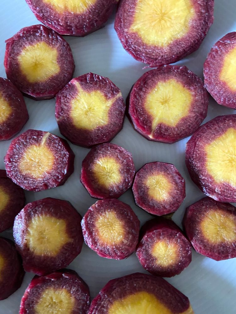 Purple heirloom carrots sliced in rounds so the orange core is showing too. Beautiful! 
