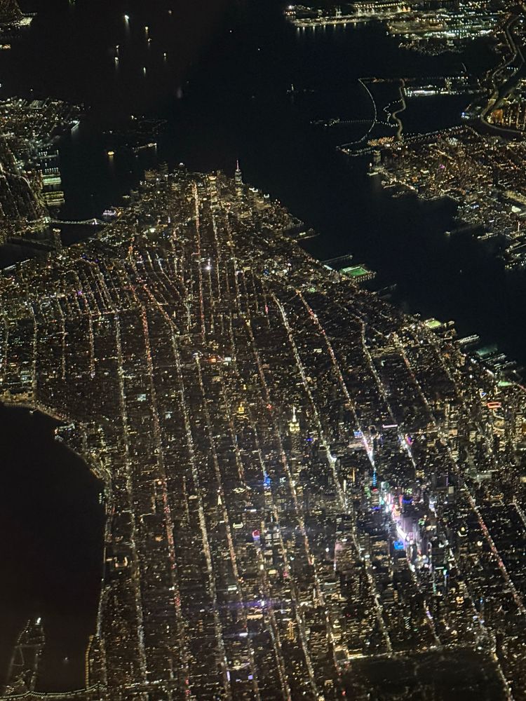 Nighttime view of Manhattan from Central Park south and the Hudson River from the air. Highly visible is Times Square.