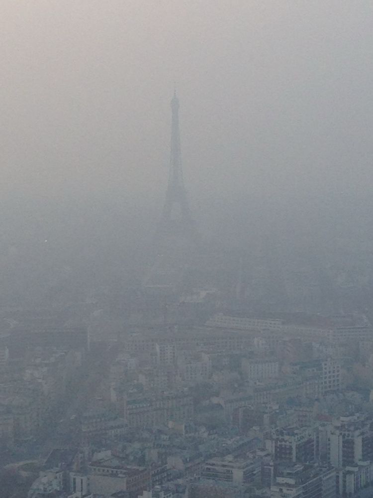 Eiffel Tower shrouded in smog. Viewed from the tour Montparnasse observation deck.