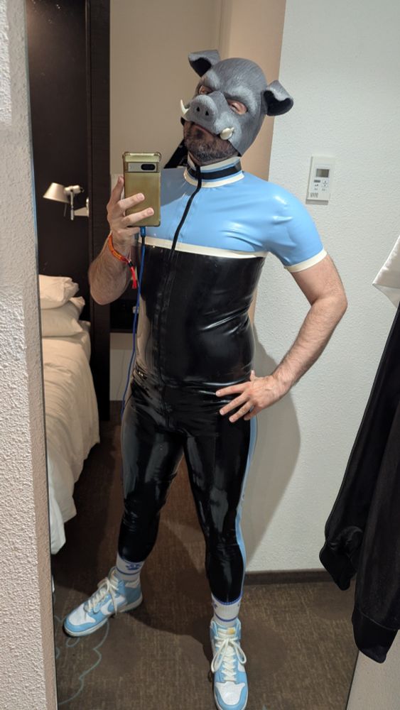 Some weird pig dude in light blue and black rubber with matching trainers that he wouldn't mind if you licked~