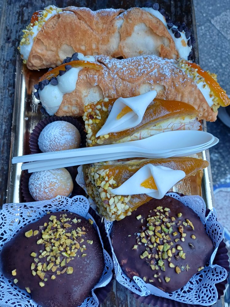 A tray of 8 pastries, including cannoli e cassata