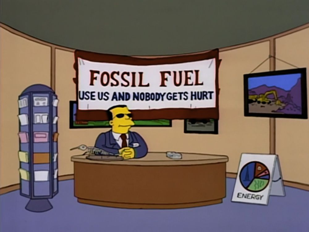 A screenshot of an episode of The Simpsons (S5E9) with a booth at an energy convention. A man in dark glasses sits at a desk. The sign behind him reads FOSSIL FUEL: USE US AND NOBODY GETS HURT