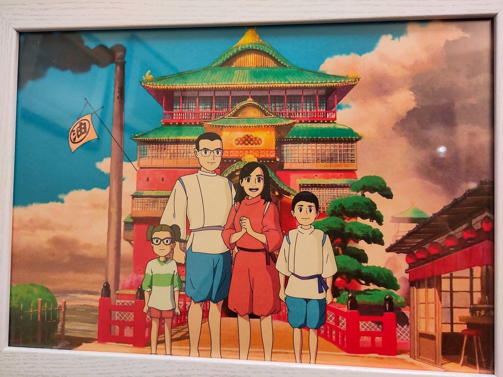 Family picture of my kids, my wife and myself in Spirited Away style, in front of the bath house. Drawn by a human artist.