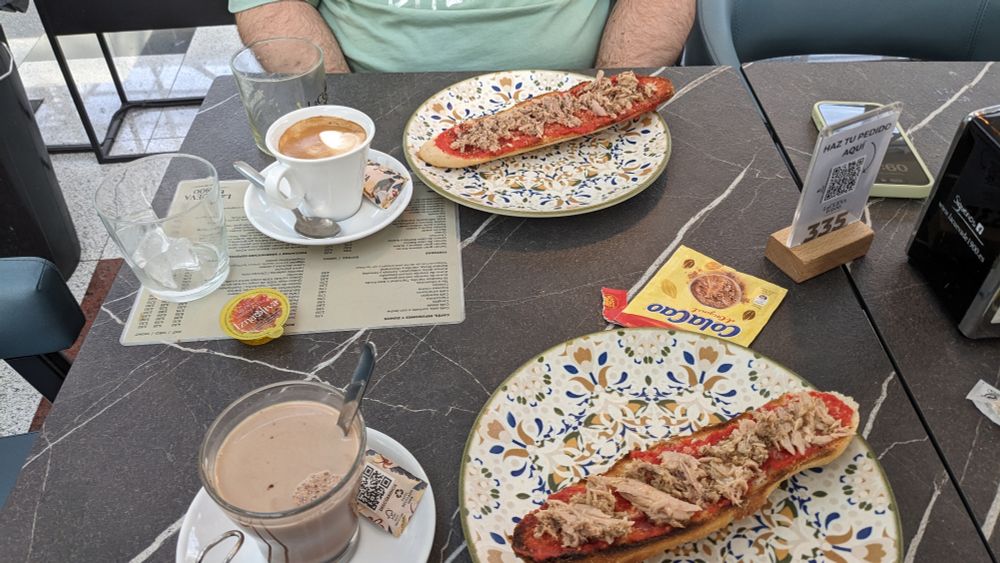 Desayuno fuera con tostadas de atún con tomate, café y Colacao 