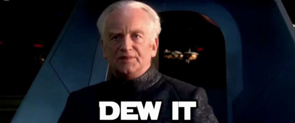 a man in a suit is sitting in a chair with the words `` dew it '' written on it .