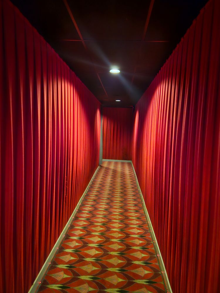 A hallway lined with dramatic red curtains