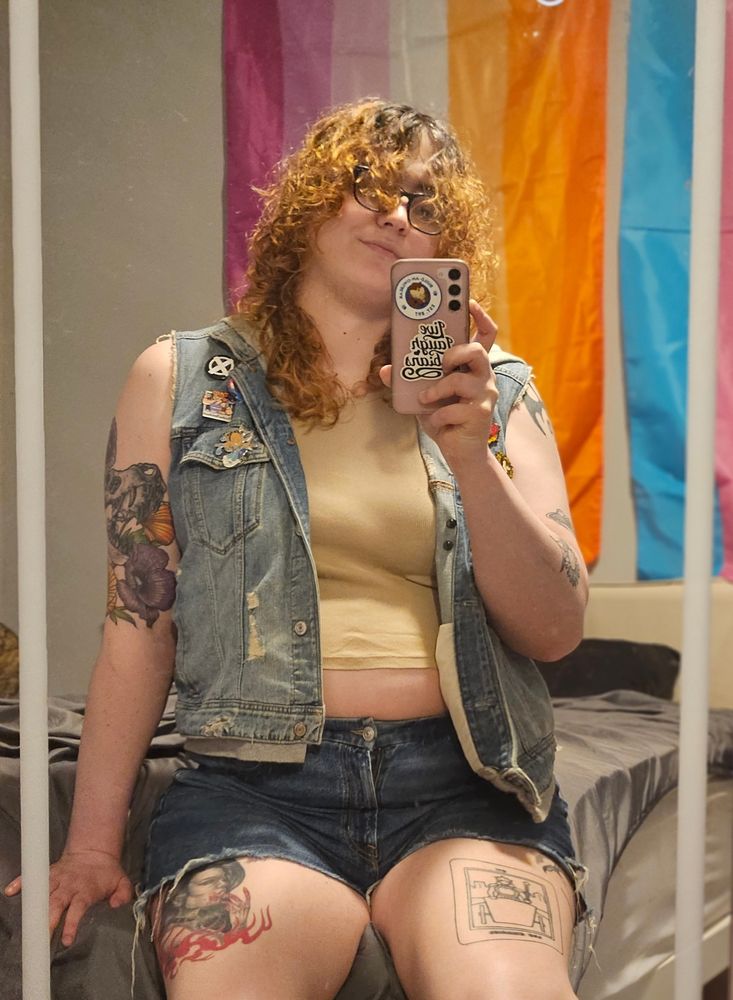A selfie of me in a crop top, denim shorts and denim vest