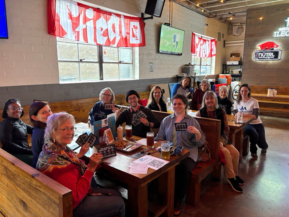 Volunteers filling out and holding up their postcards. 
