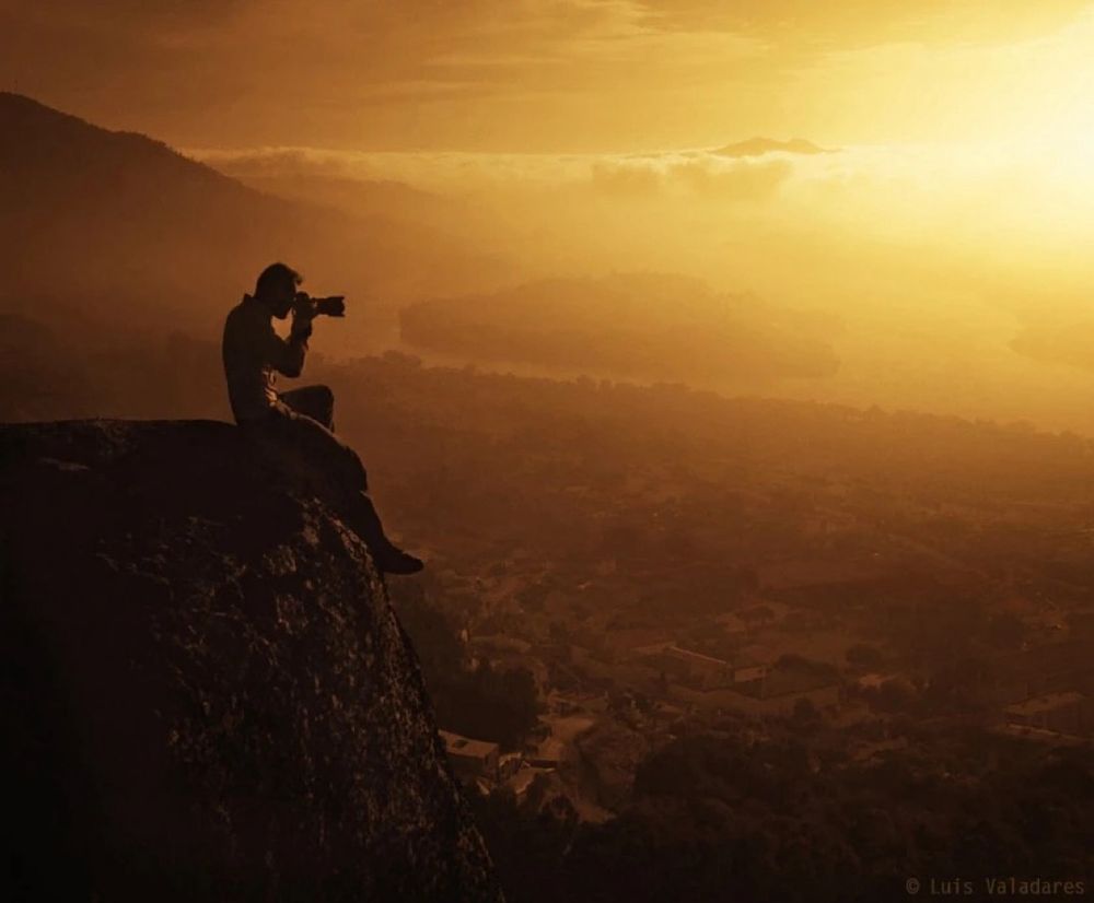 Un photographe assis en bord de falaise au coucher du soleil. Le #photographe Luis Valadares pour un magnifique coucher de soleil, bonne #nuit, à demain.