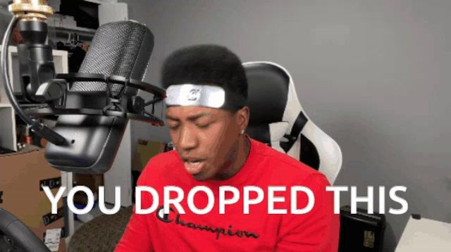 a man sitting in front of a microphone with the words " you dropped this " on the bottom