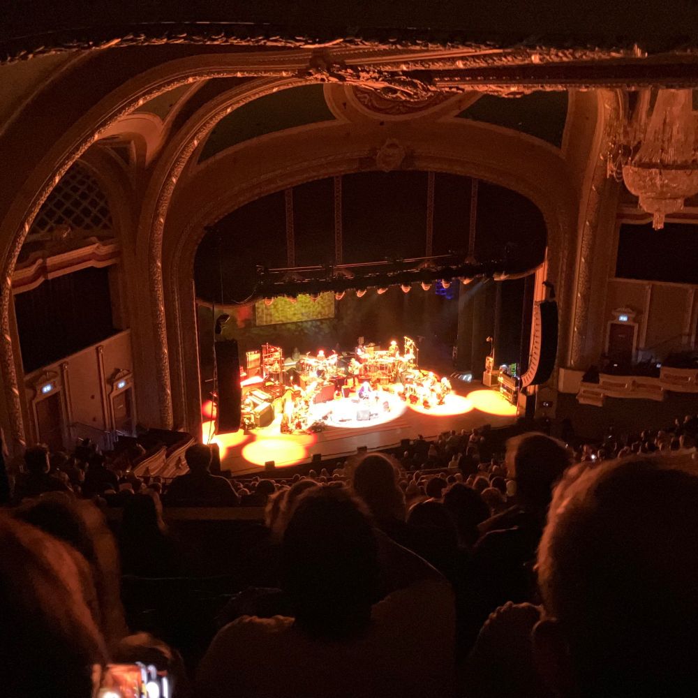Interior of the Orpheum Theater in Minneapolis, Minnesota. Paul Simon and his band are viewed onstage from a high angle in the balcony.