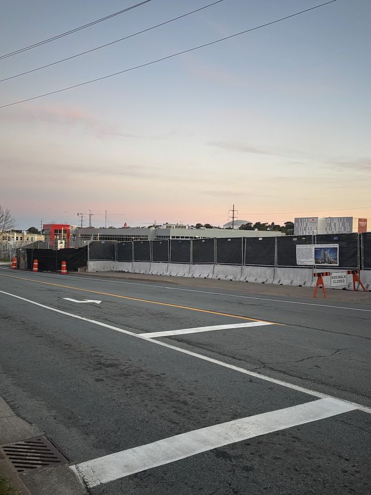 A development blocks a sidewalk. There is a "Sidewalk Closed" sign with no noticeable accommodations for pedestrians