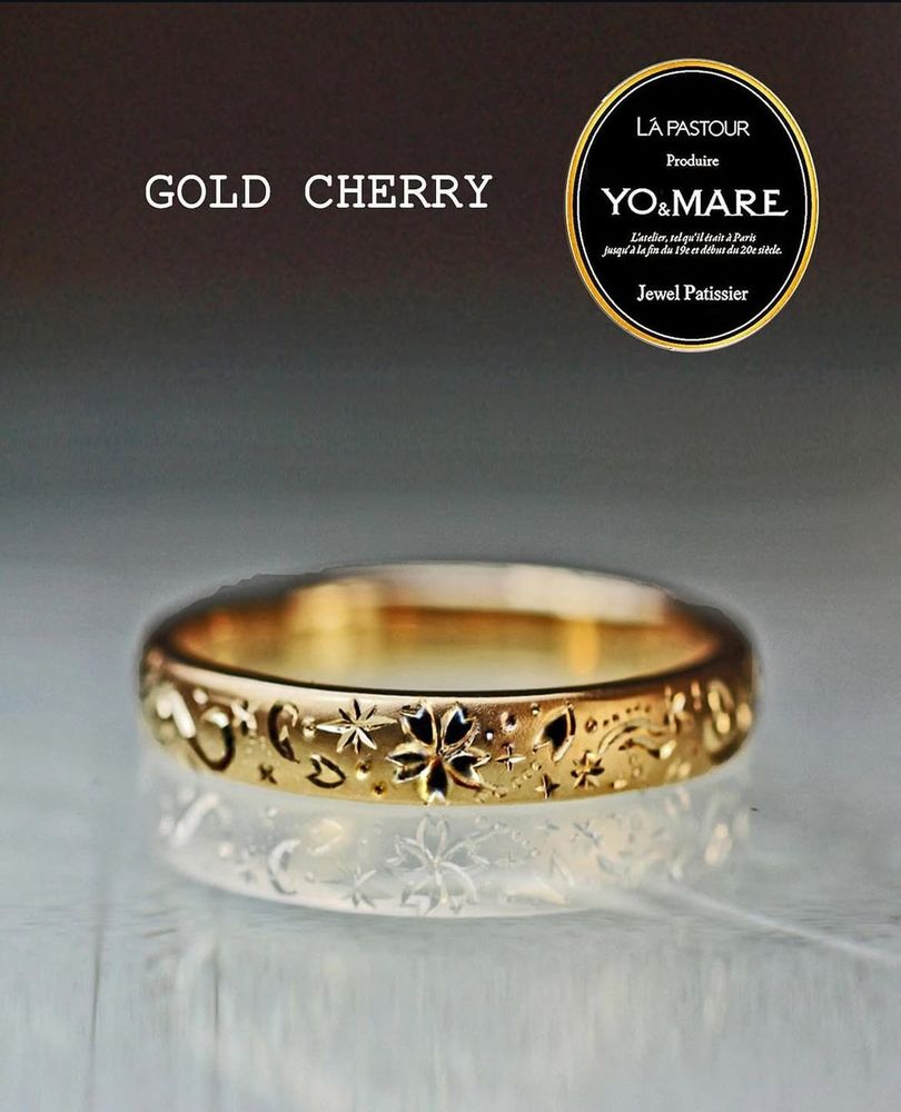 ゴールドリングにサクラ５枚花と花びらが舞う模様を手彫りで一周に描いた10周年の結婚指輪オーダーメイド作品