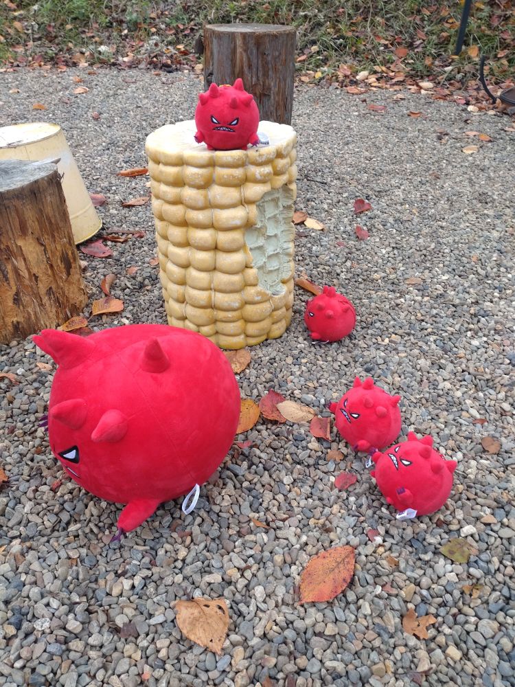 ビーストくん小たちが齧られたとうもろこしの横にいる大きいビーストをそれぞれの位置からじっと見ている写真。大きいビーストくんはみんなに背中を向けている。