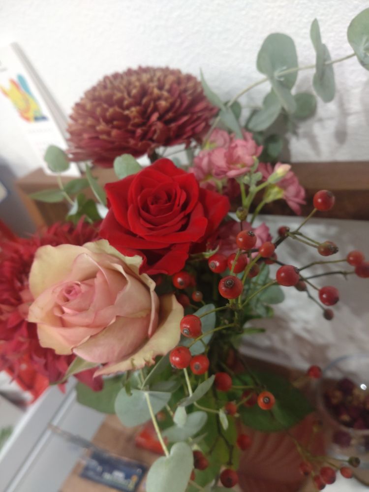 1枚目の写真を上から撮って花材を分かりやすくした写真。真ん中に赤いバラが写っている。